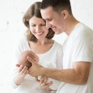 padre-e-madre-con-un-bambino-in-braccio_1218-536